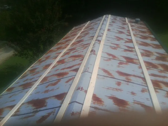 Rusted metal roof panels with new wood purlins before replacement — Storm Damage Roof Repair in Caroleen by Roofing Brothers