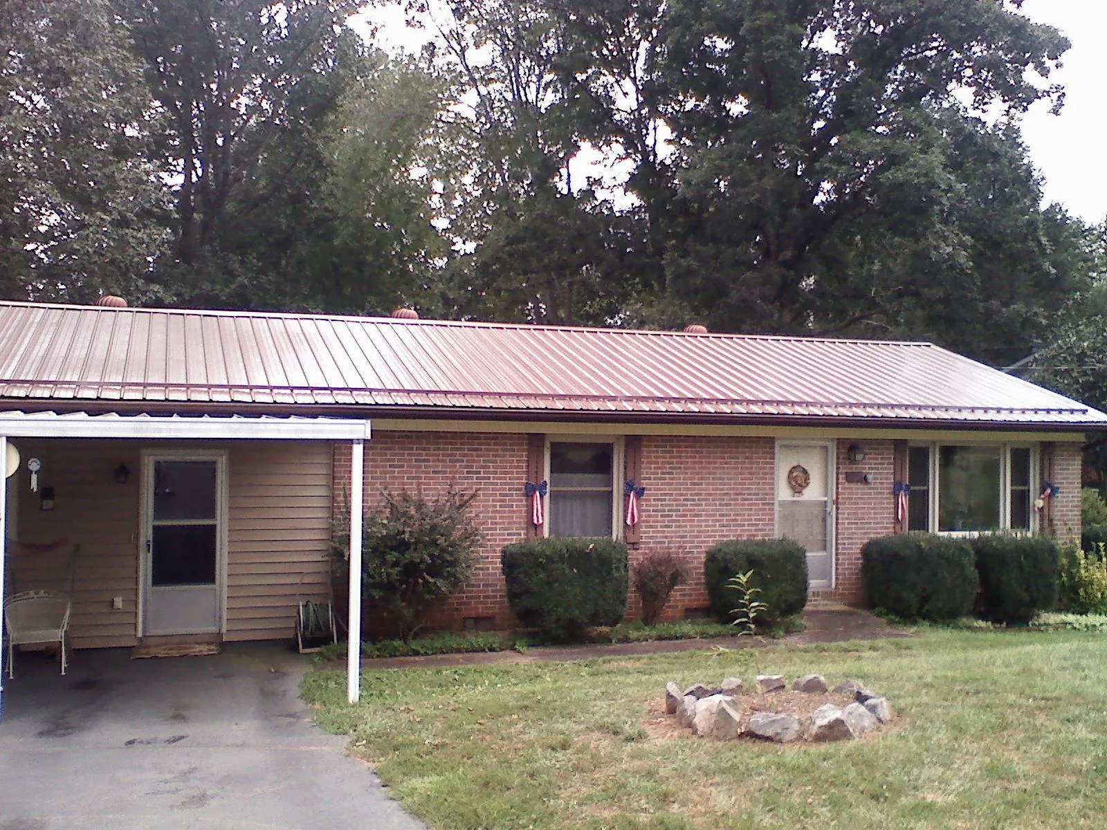 Bronze metal roof and carport on a brick ranch home — Roof Repair work by our crew in Caroleen