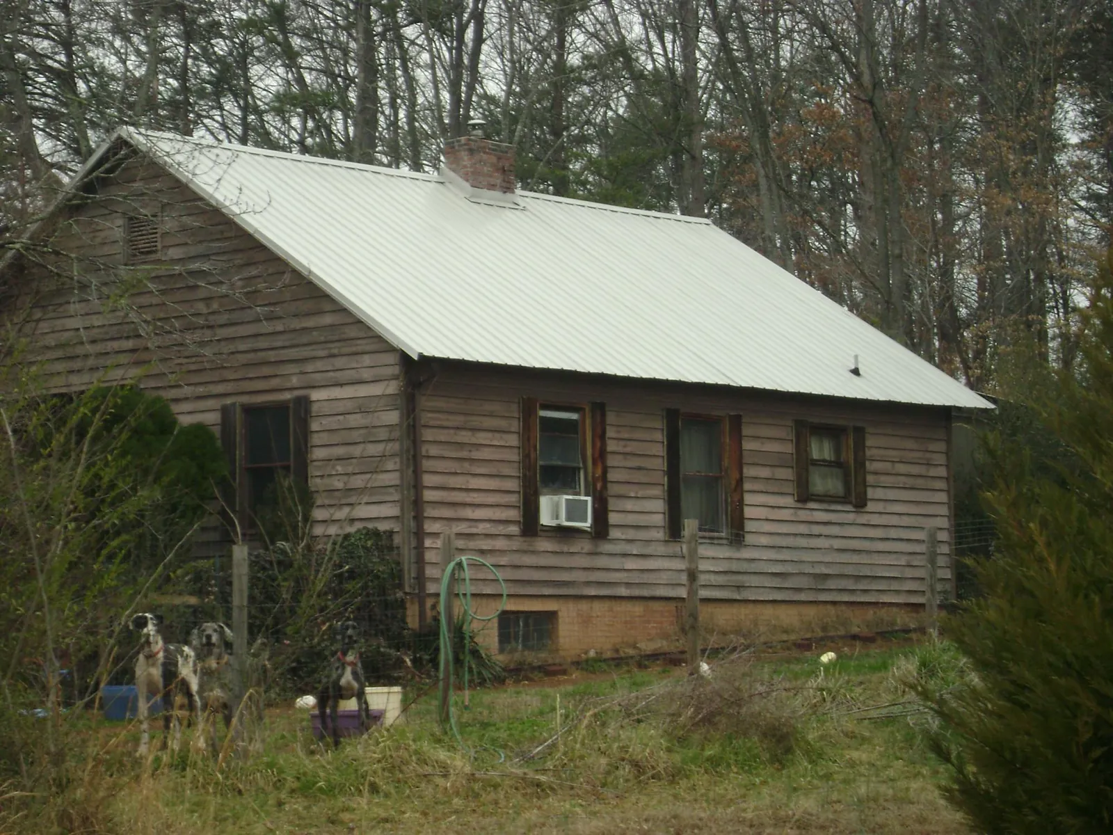 White metal roof on an old wood sided farmhouse, from a Metal Roof Installation job in Caroleen